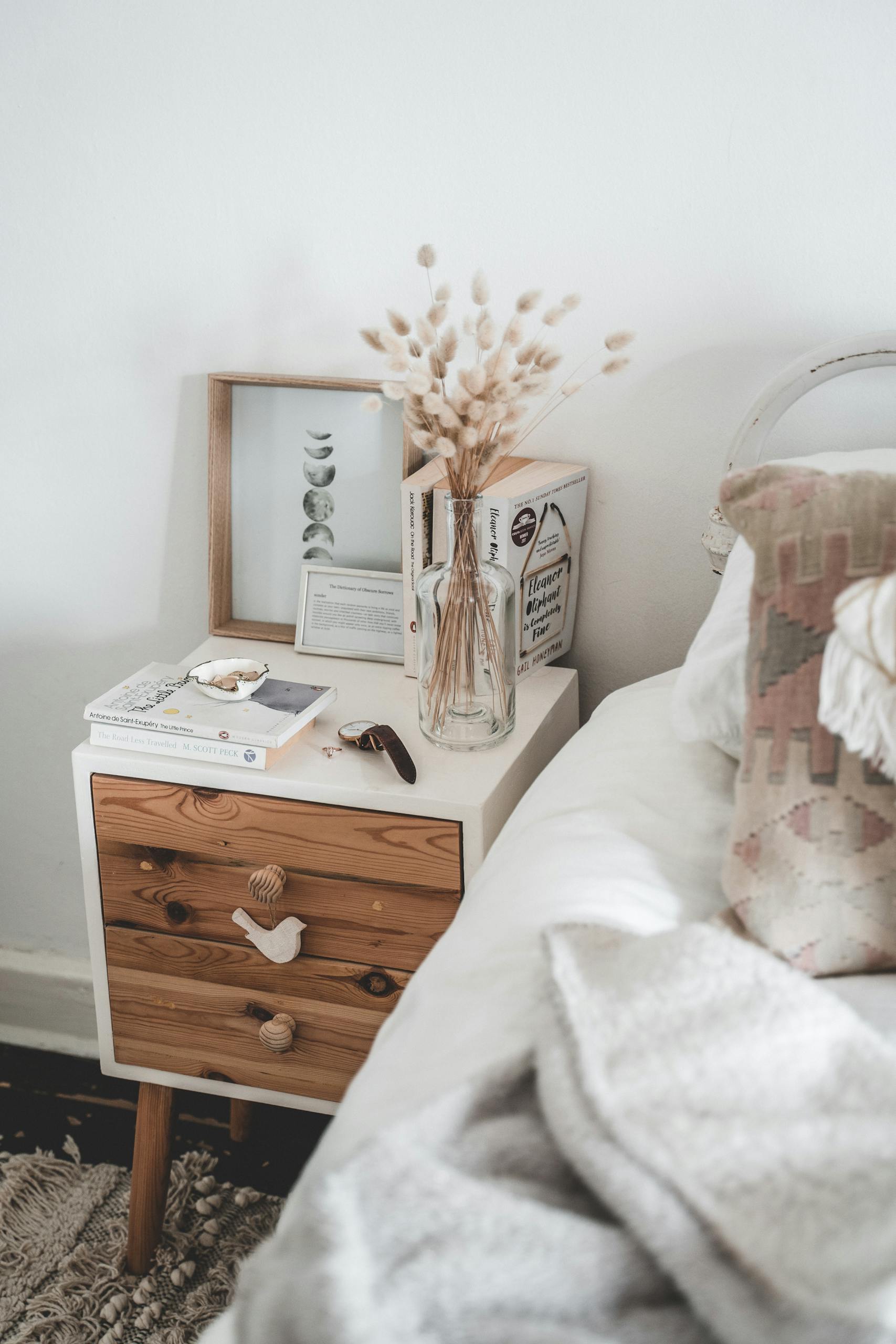 Minimalist bedroom featuring a wooden bedside table with natural accents and warm tones.