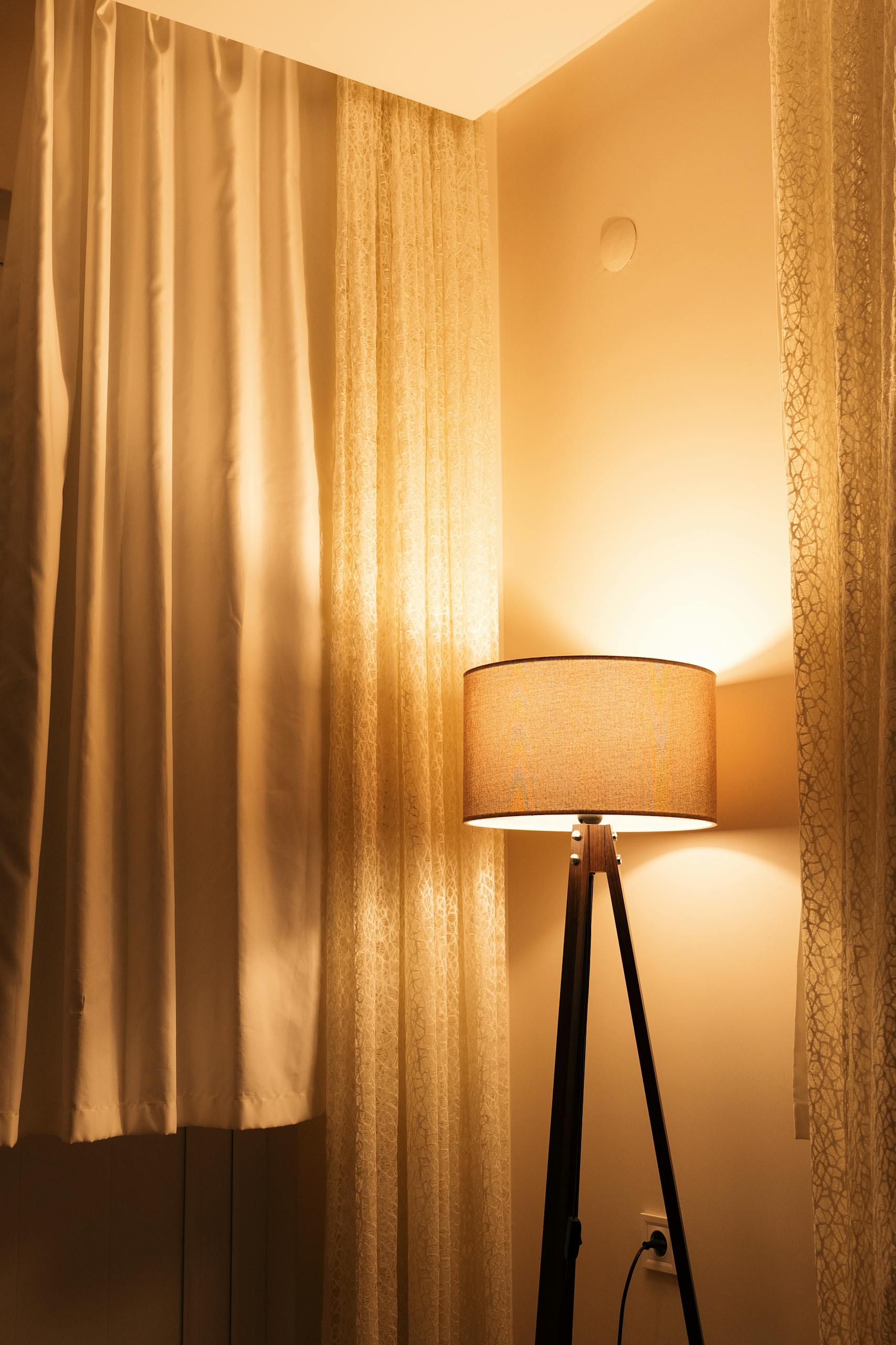 Warm lighting from a floor lamp in an elegant, softly lit interior room.