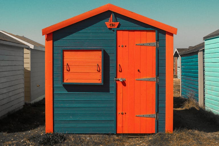 Eye-catching orange and blue wooden beach hut with unique design details, perfect for architectural stock imagery.