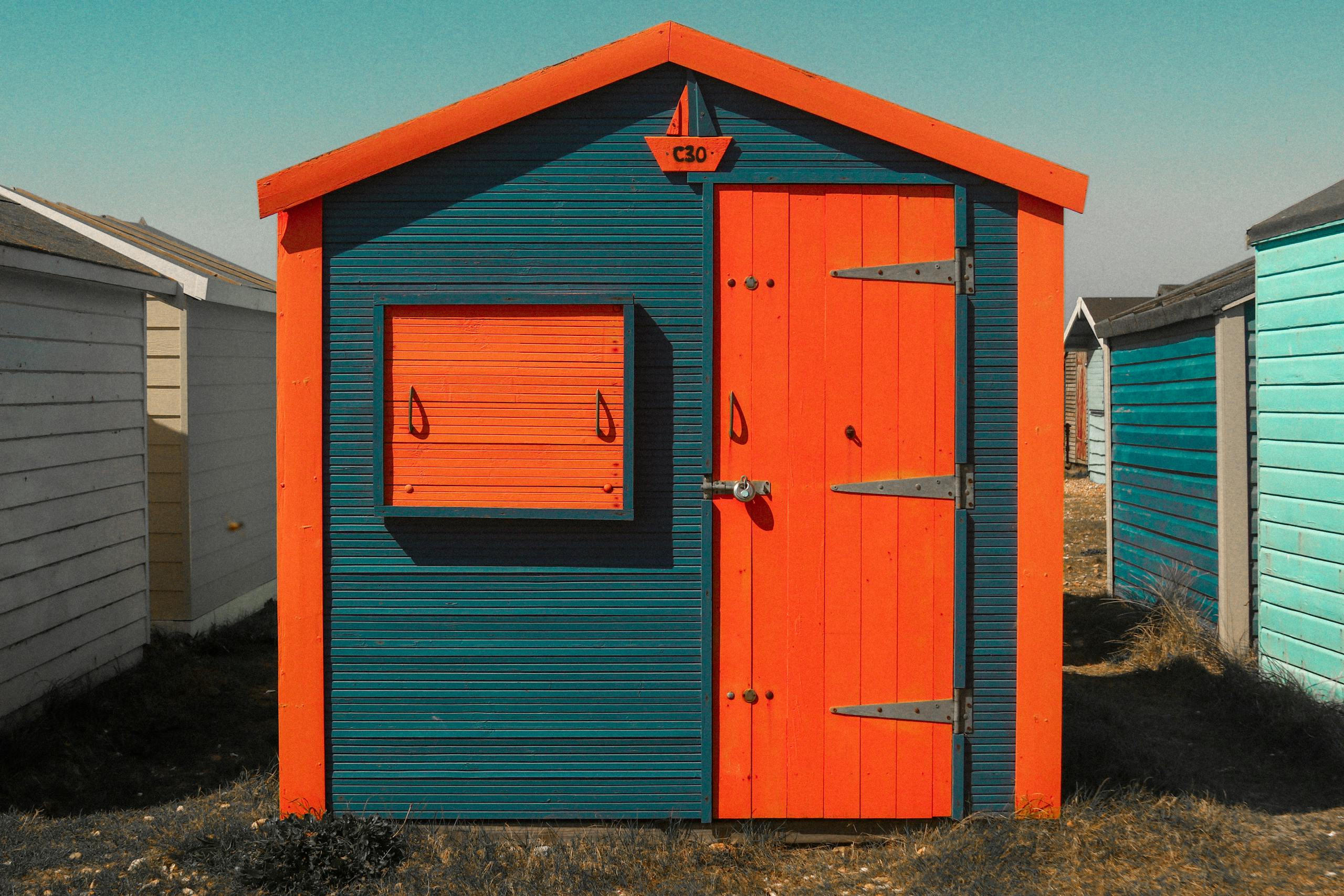Eye-catching orange and blue wooden beach hut with unique design details, perfect for architectural stock imagery.